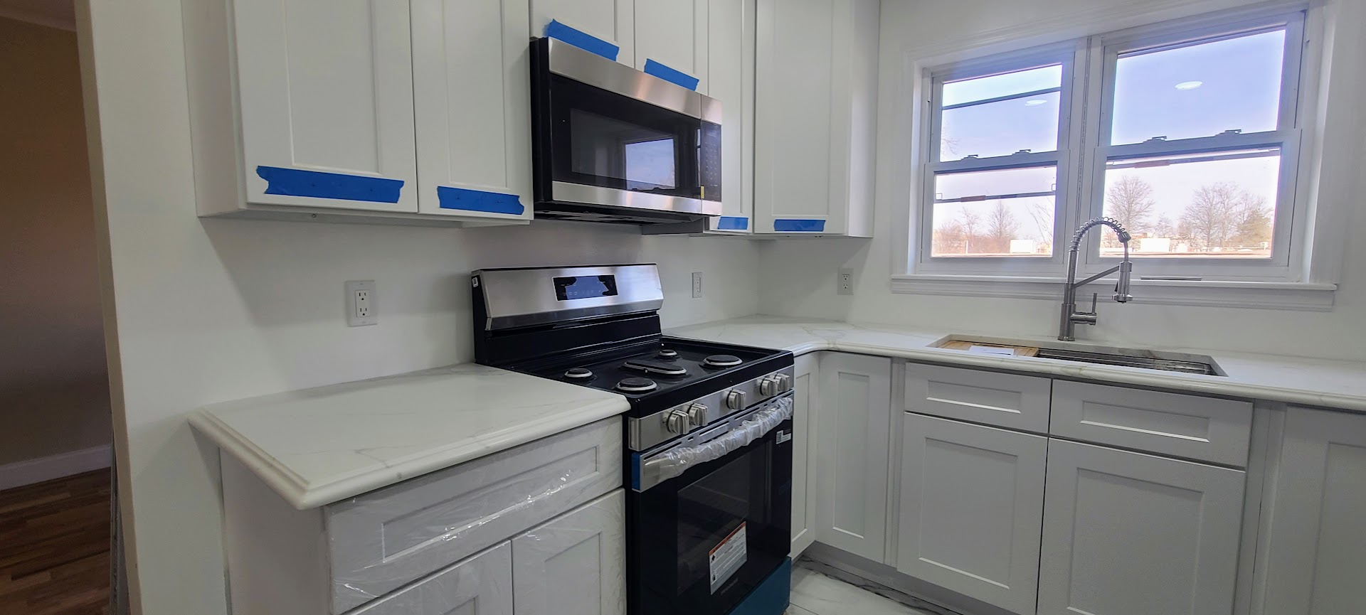 97-08 Plattwood Avenue, Unit 2 Queens, NY 11417 - Photo 3 of 10 a kitchen with stainless steel appliances granite countertop a sink stove and microwave