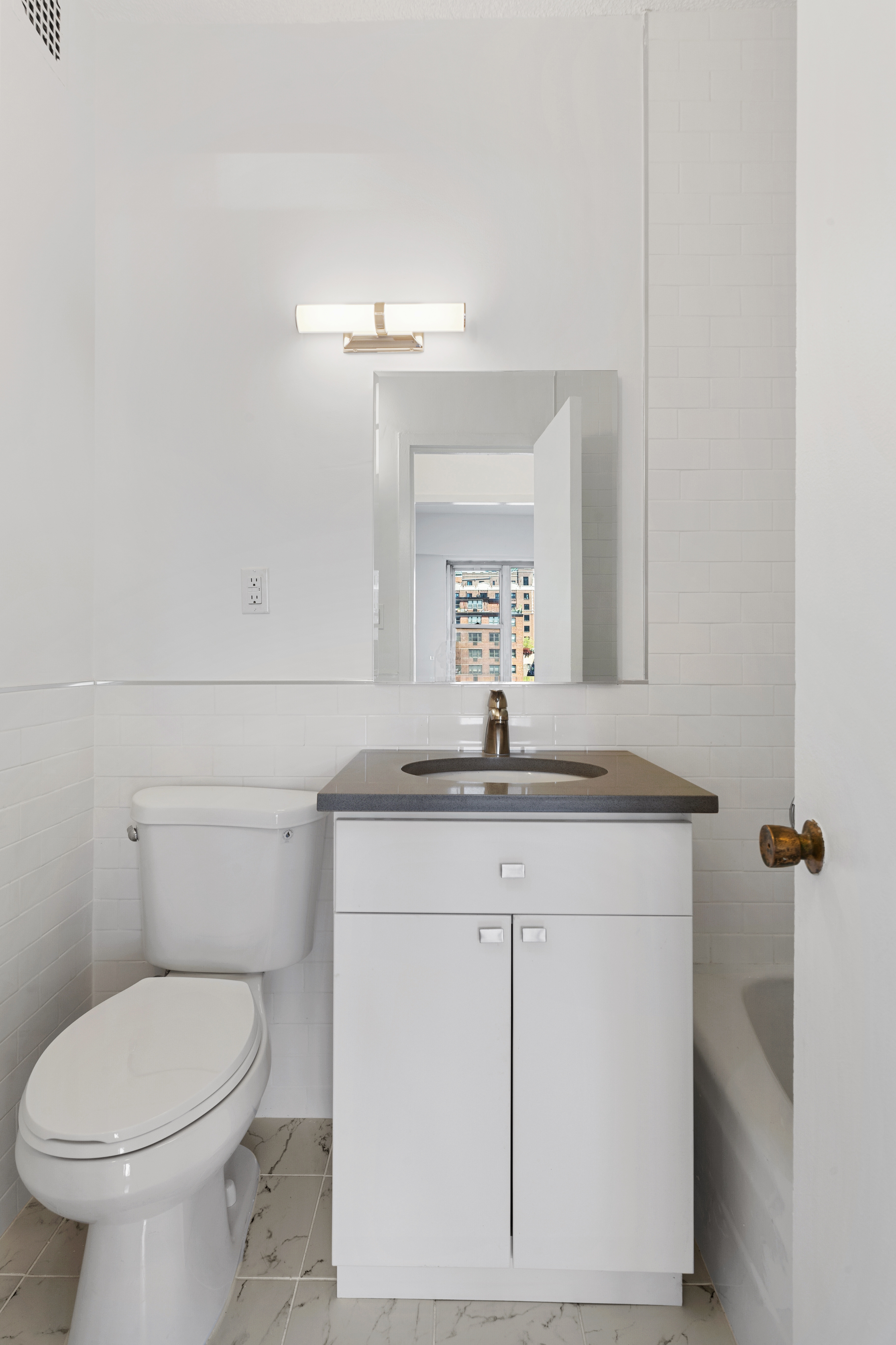 60 East 8th Street, Unit 9J Manhattan, NY 10003 - Photo 8 of 13 a bathroom with a toilet sink and mirror