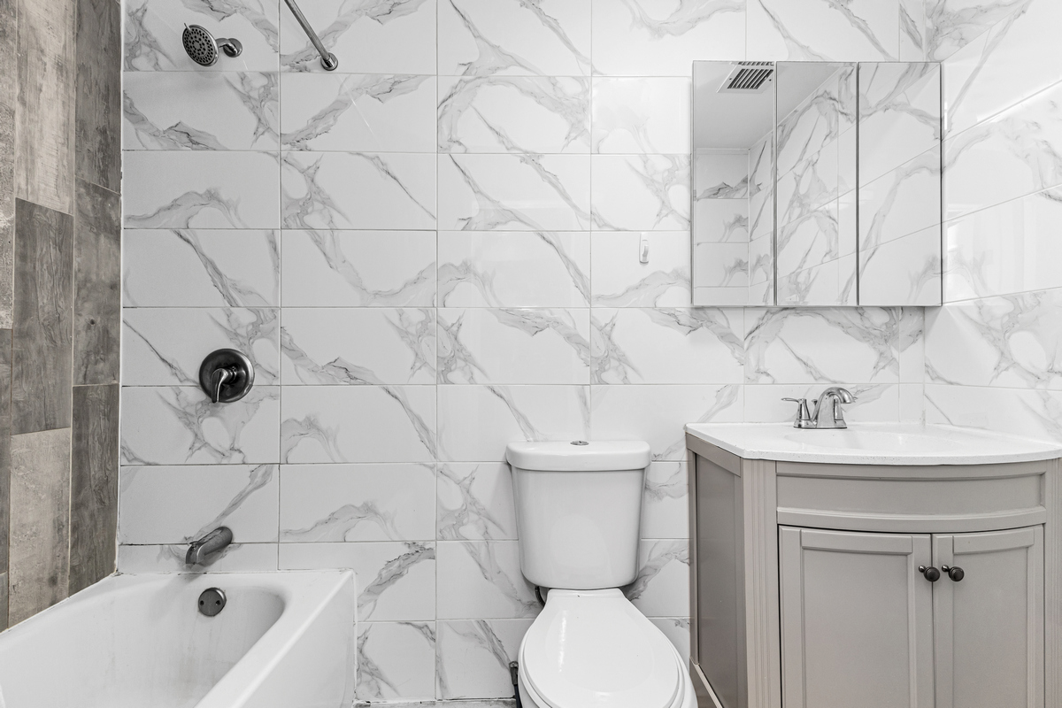 583 Evergreen Avenue Brooklyn, NY 11221 - Photo 5 of 12 a bathroom with a sink a toilet and shower