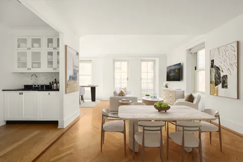 a kitchen with a table chairs stove and wooden floor