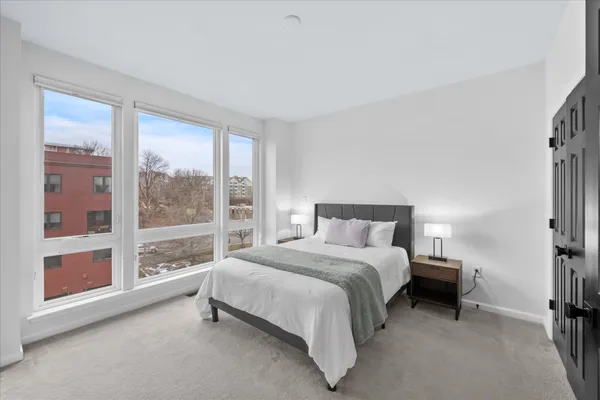 a bedroom with a bed and a large window