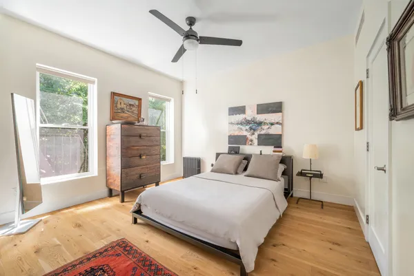 a bedroom with a bed and dresser with mirror