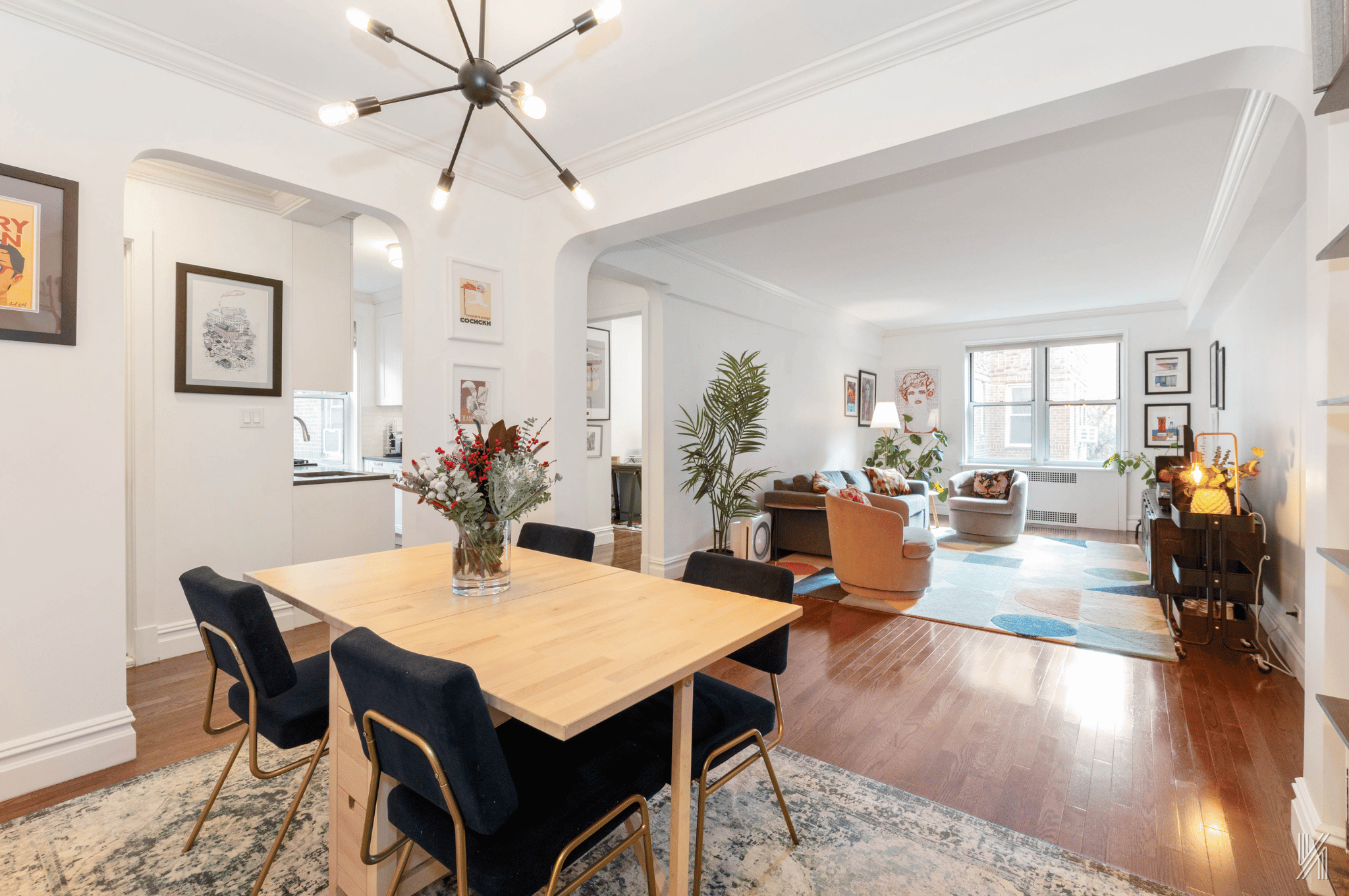 a view of a dining room and livingroom with furniture wooden floor a chandelier