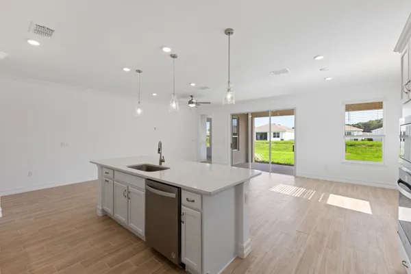 a kitchen with stainless steel appliances granite countertop a sink a stove and a wooden floors