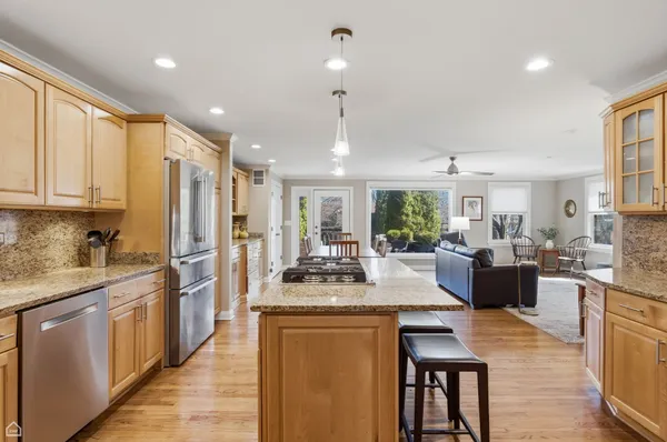 a kitchen with kitchen island granite countertop lots of counter top space and stainless steel appliances