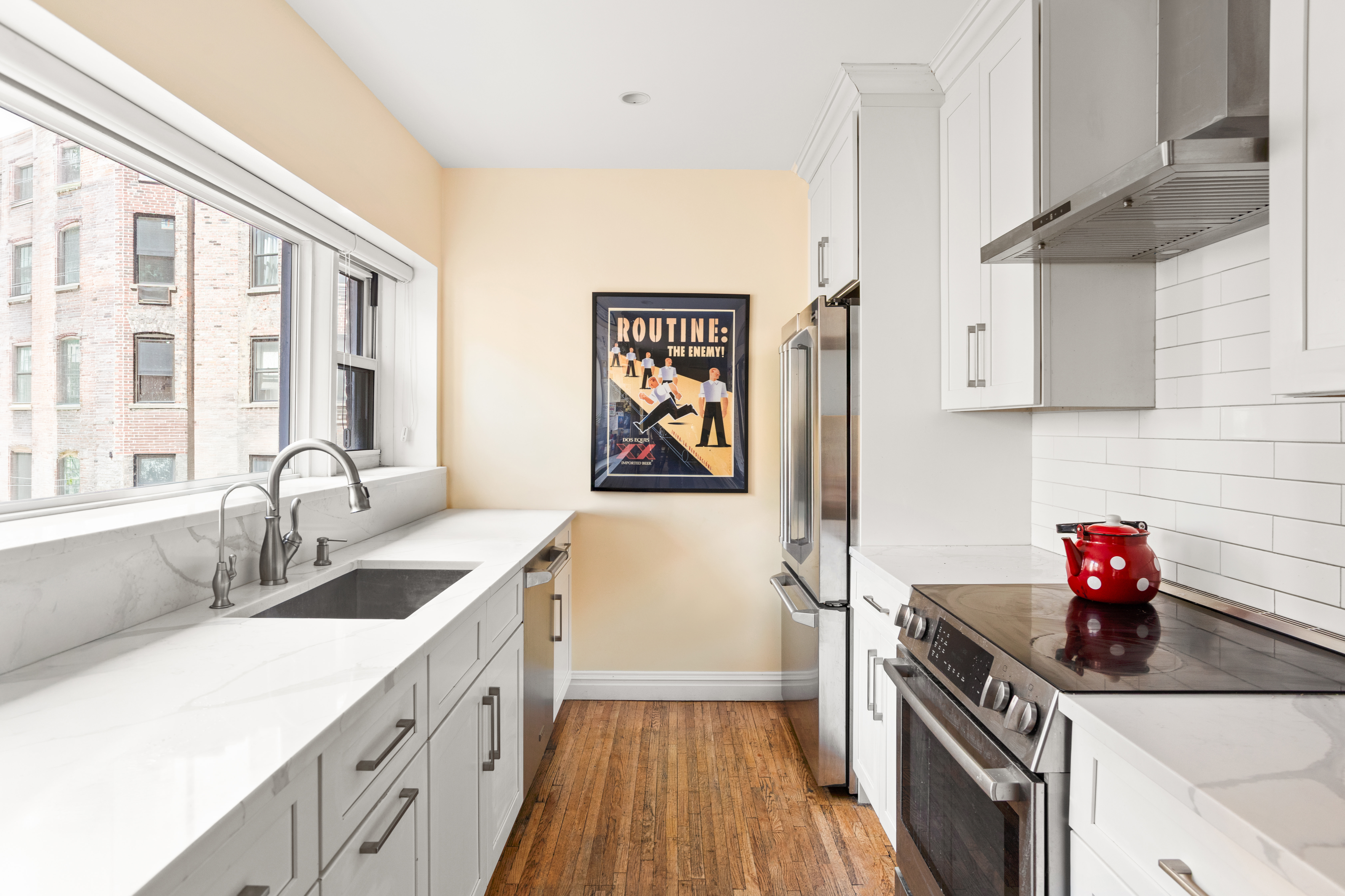 161 East 90th Street, Unit 5C Manhattan, NY 10128 - Photo 1 of 14 a kitchen with a sink cabinets and wooden floor