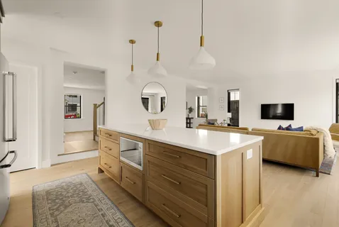 a large kitchen with kitchen island a sink stainless steel appliances and living room view