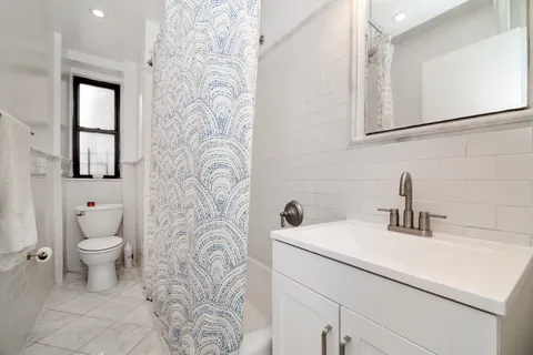 a bathroom with a sink a toilet and a mirror