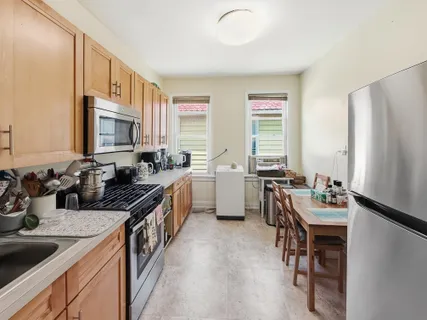 a kitchen with a sink stove and chairs