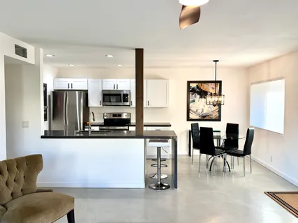 a living room with stainless steel appliances kitchen island granite countertop furniture and a view of kitchen