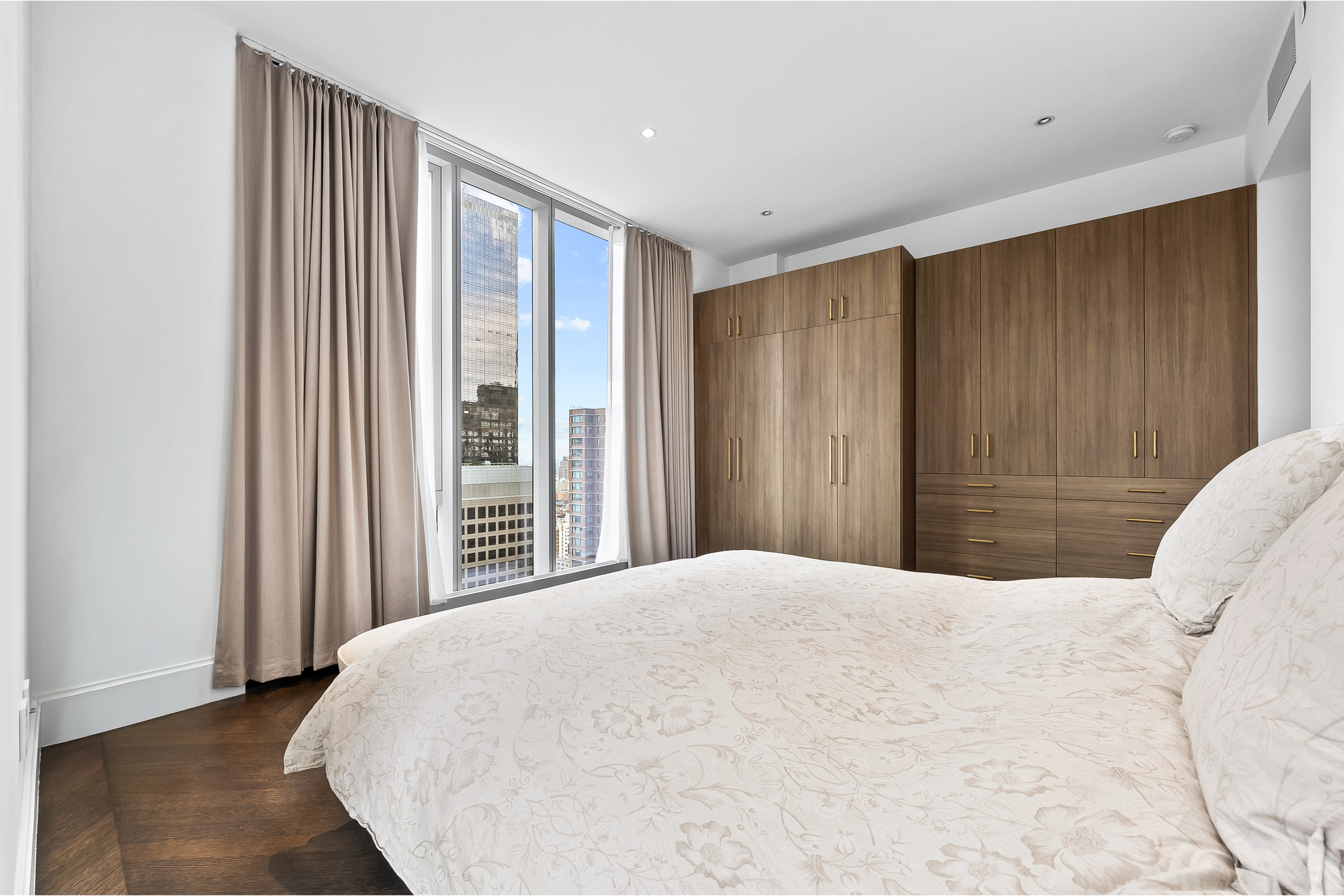 217 West 57th Street, Unit 36D Manhattan, NY 10019 - Photo 7 of 26 a bedroom with a large bed and a closet