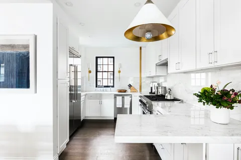 a kitchen with stainless steel appliances granite countertop a sink a stove and a wooden floors