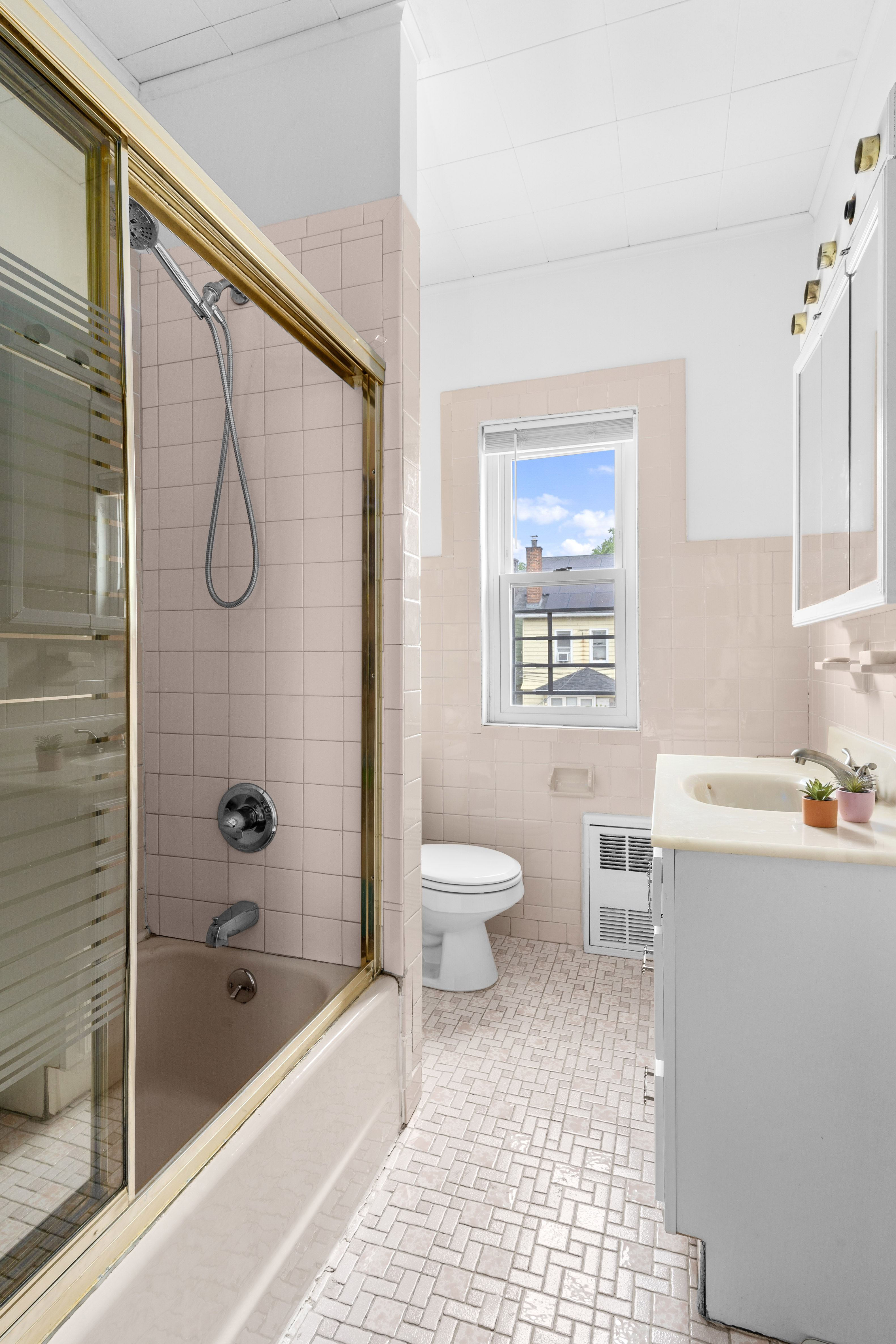 1065 East 39th Street Brooklyn, NY 11210 - Photo 8 of 15 a bathroom with a granite countertop sink a toilet and shower