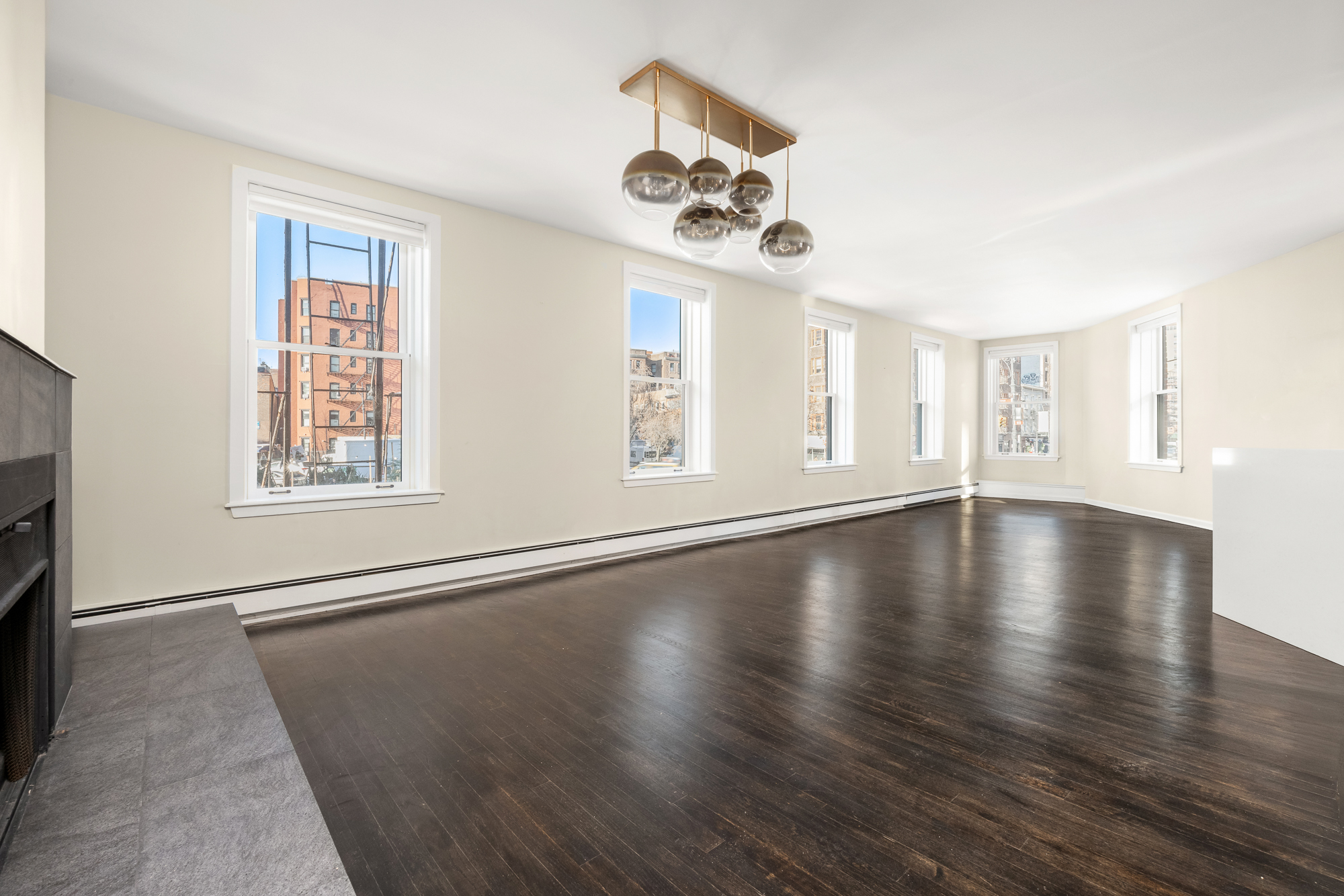 160 West 11th Street, Unit 1 Manhattan, NY 10011 - Photo 2 of 18 a view of an empty room with wooden floor and a window