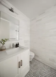 a bathroom with a sink a toilet and a mirror