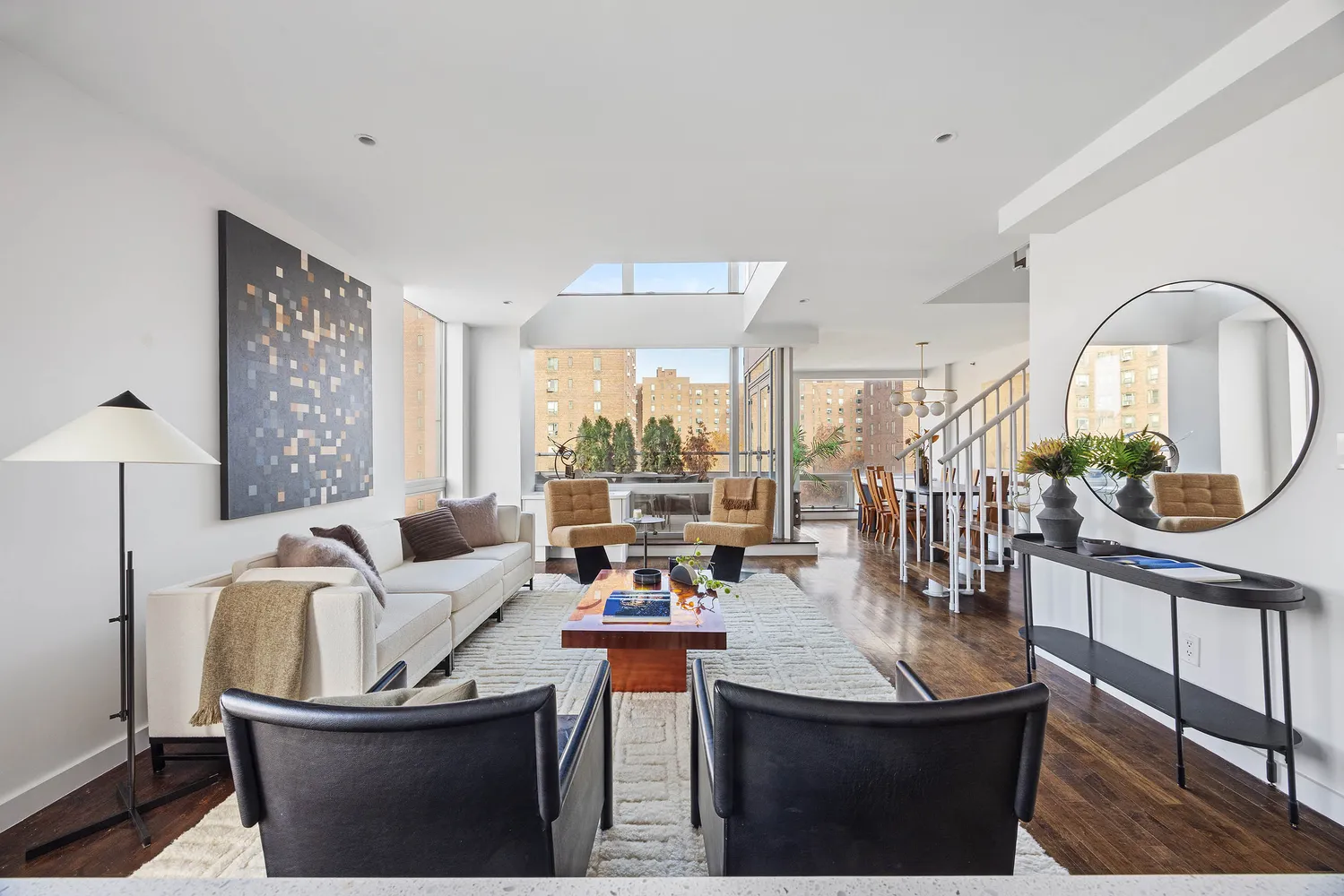 a living room with furniture a window and a potted plant