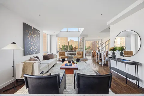 a living room with furniture a window and a potted plant