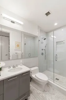 a bathroom with a sink a toilet and shower