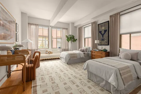 a bedroom with two beds and a large window