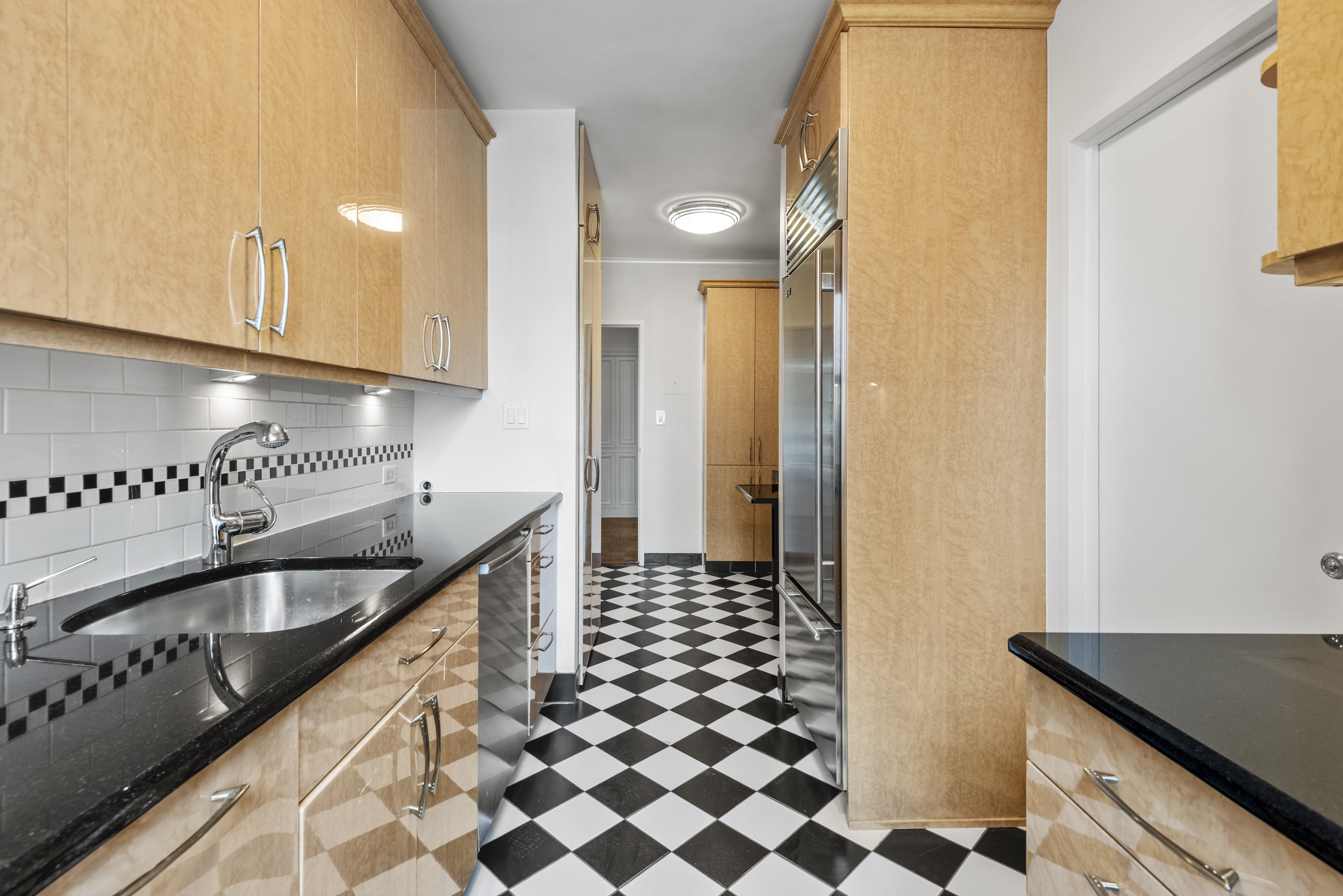 175 East 62nd Street, Unit 12A Manhattan, NY 10065 - Photo 5 of 24 a kitchen with granite countertop stainless steel appliances a sink and cabinets