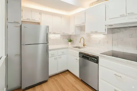 a kitchen with a refrigerator stove and white cabinets