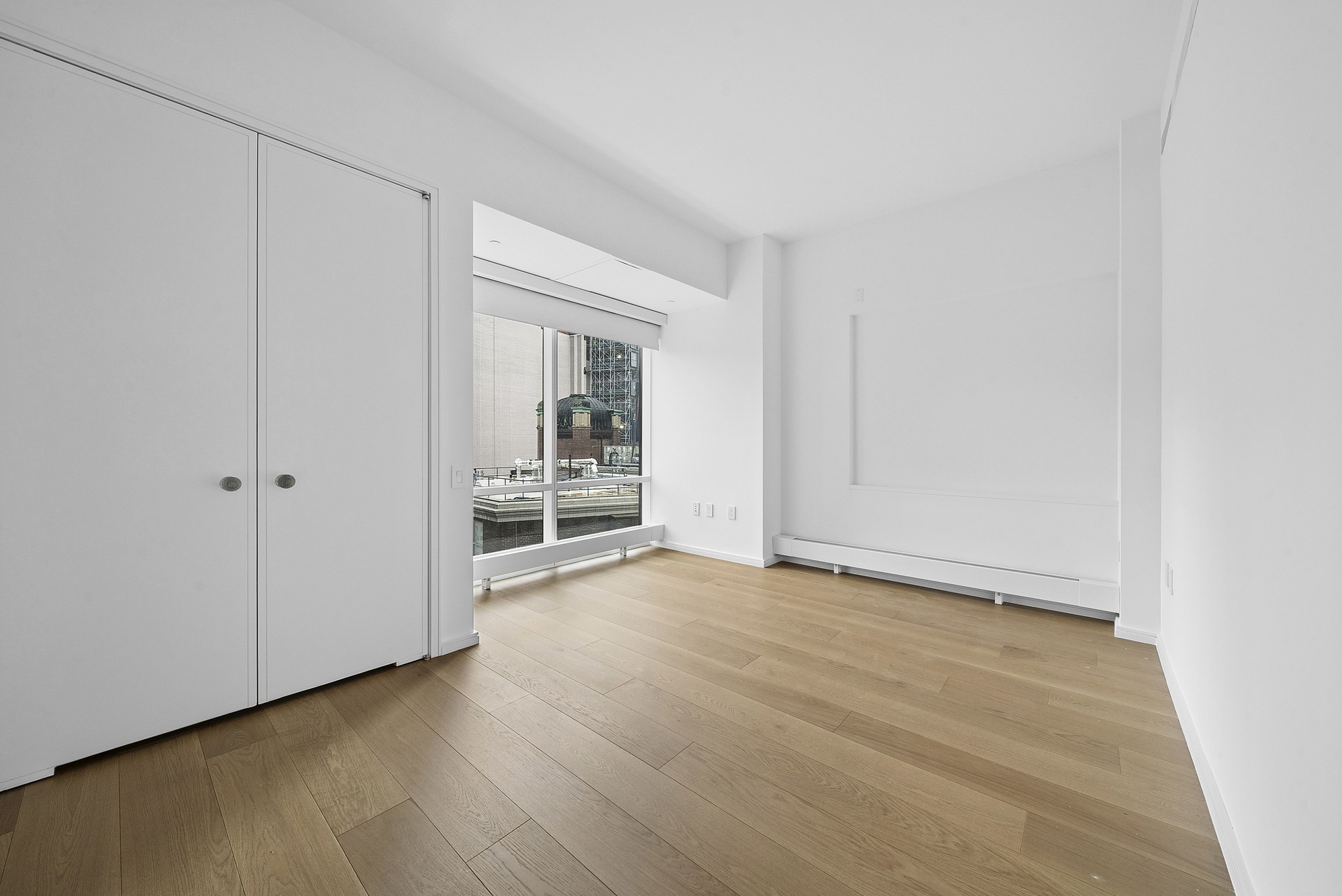 5 Beekman Street, Unit 30A Manhattan, NY 10038 - Photo 8 of 15 a view of an empty room with wooden floor and a window
