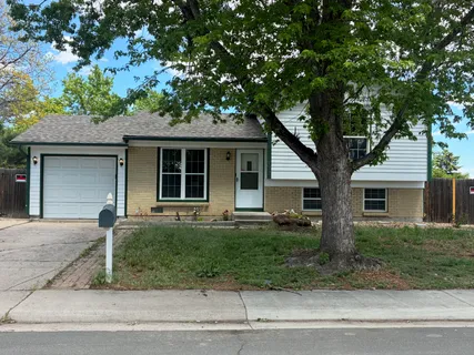 a front view of a house with a garden and trees