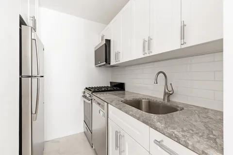 a kitchen with stainless steel appliances granite countertop a sink and a refrigerator