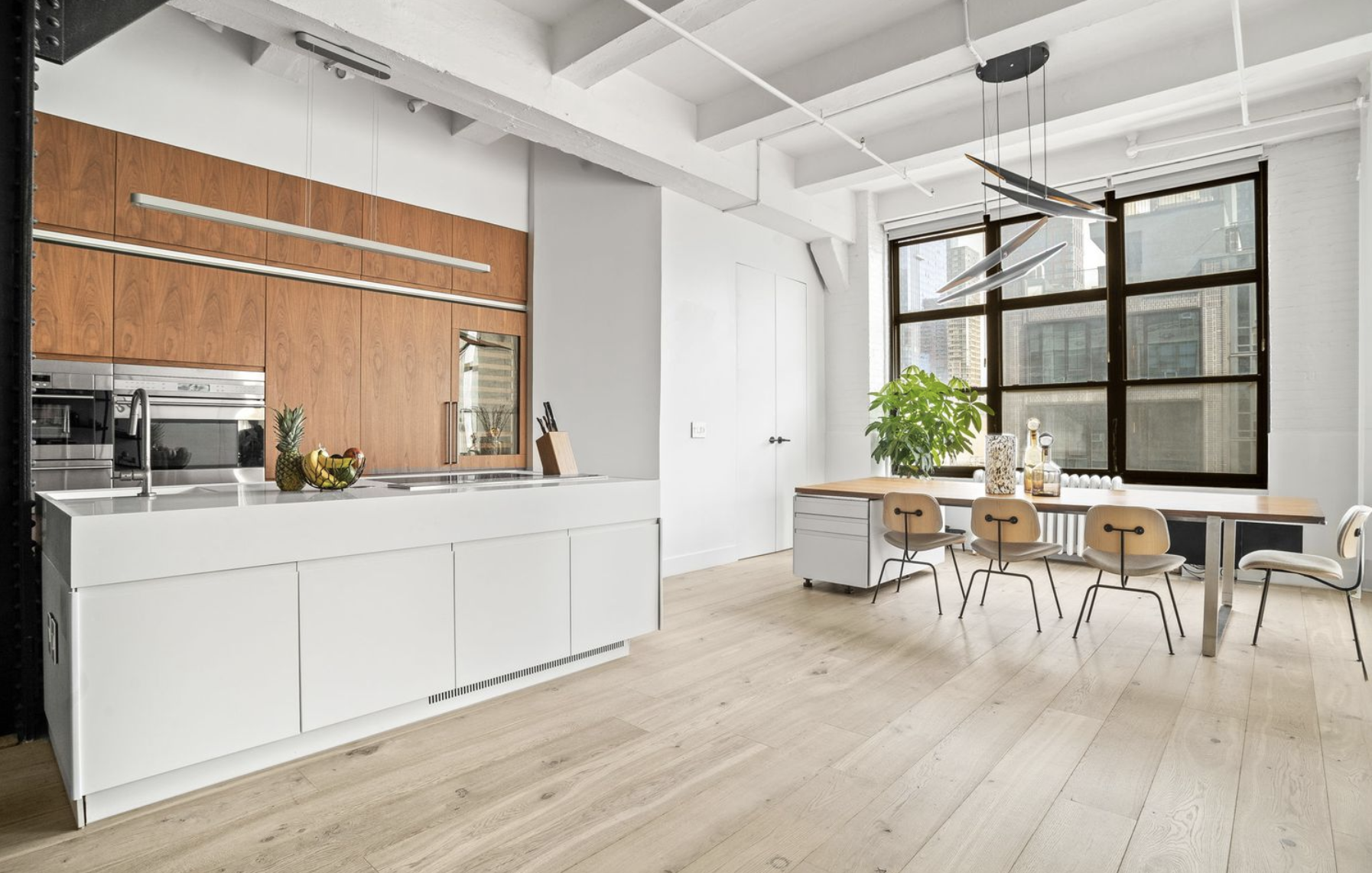 448 West 37th Street, Unit 8C Manhattan, NY 10018 - Photo 3 of 10 a living room with stainless steel appliances granite countertop furniture a desk and chair with wooden floor