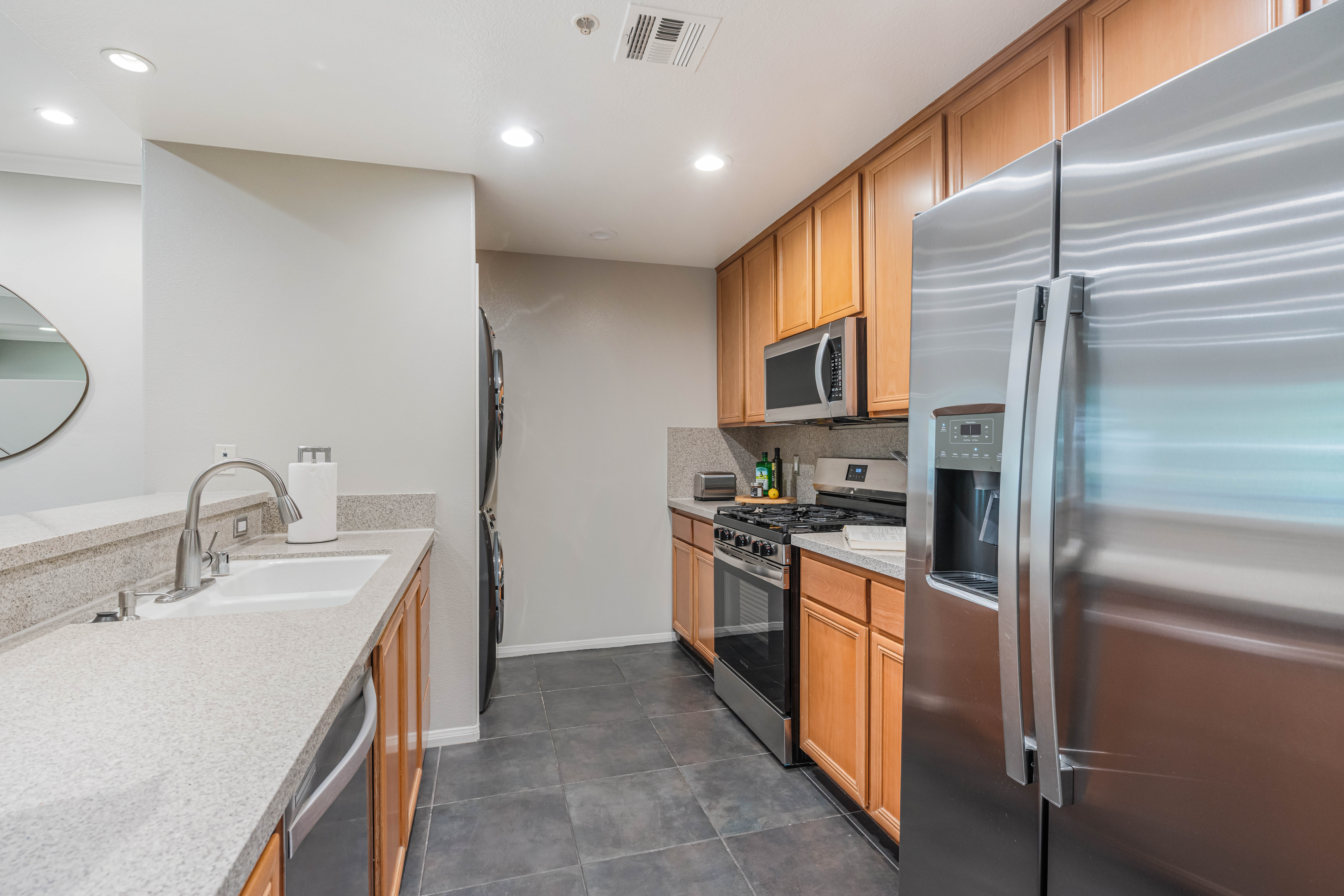 12963 West Runway Road Playa Vista, CA 90094 - Photo 7 of 39 a kitchen with stainless steel appliances granite countertop a sink and a refrigerator