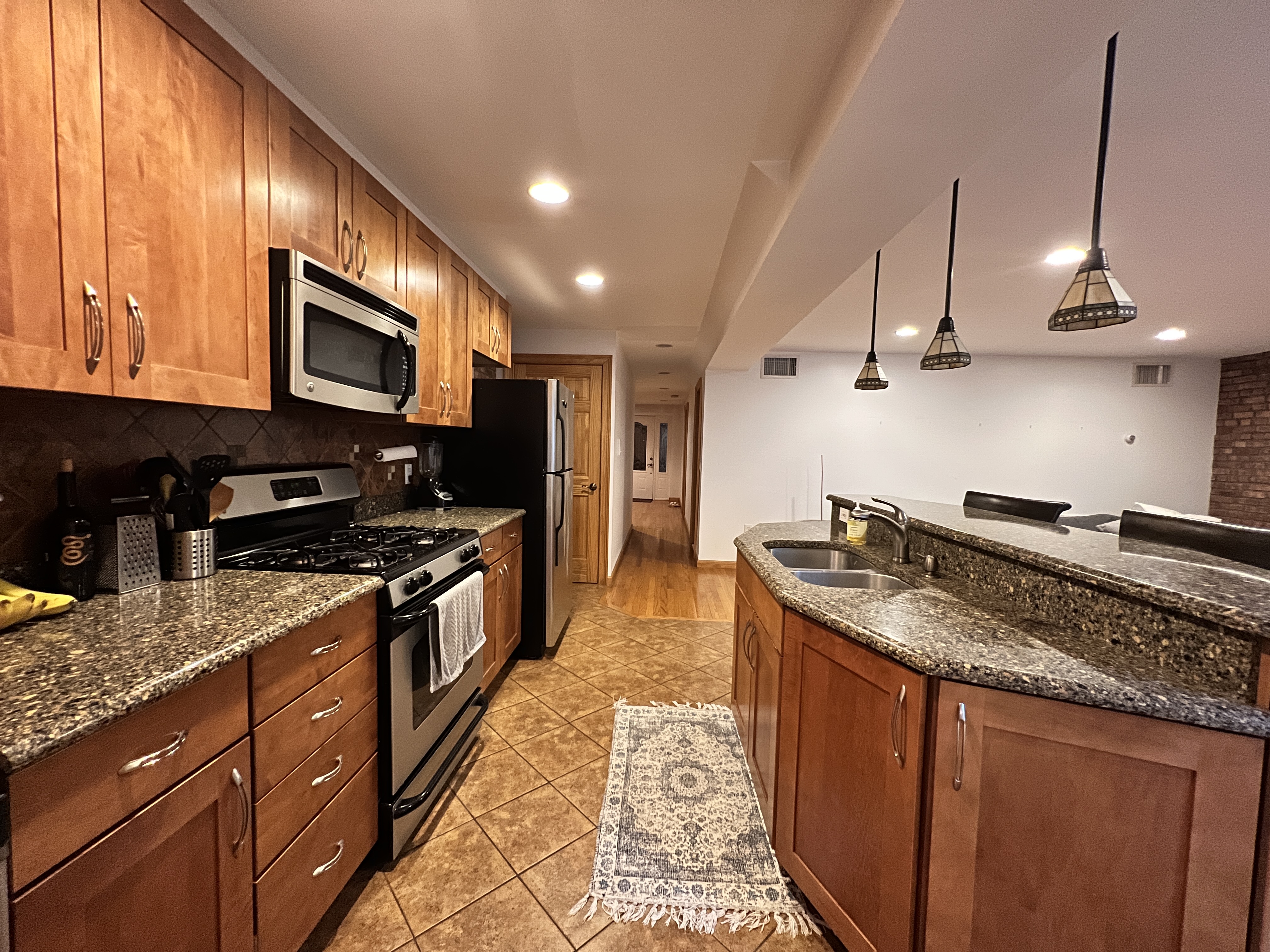75 Warren Street, Unit 1 Brooklyn, NY 11201 - Photo 4 of 14 a large kitchen with stainless steel appliances granite countertop a stove a sink dishwasher and a refrigerator with wooden cabinets