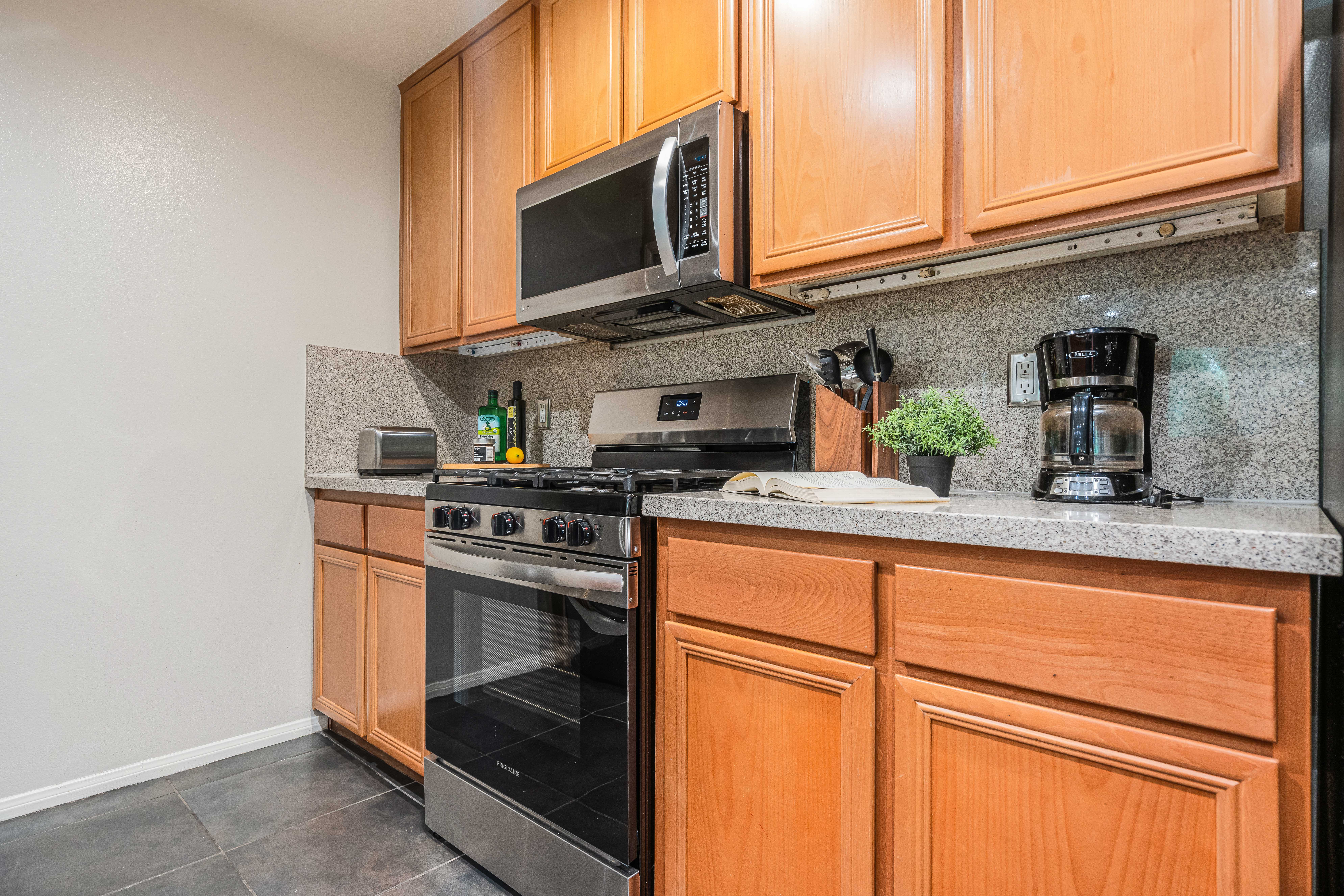 12963 West Runway Road Playa Vista, CA 90094 - Photo 6 of 39 a kitchen with stainless steel appliances granite countertop a sink stove and microwave