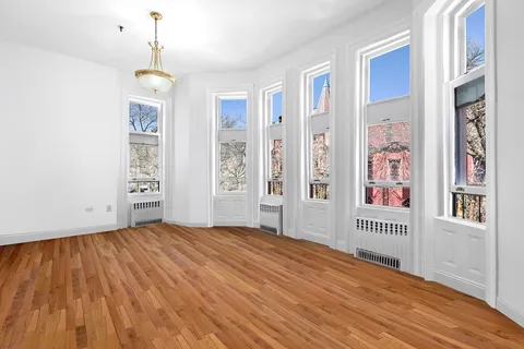 a view of an empty room with cabinet and a window