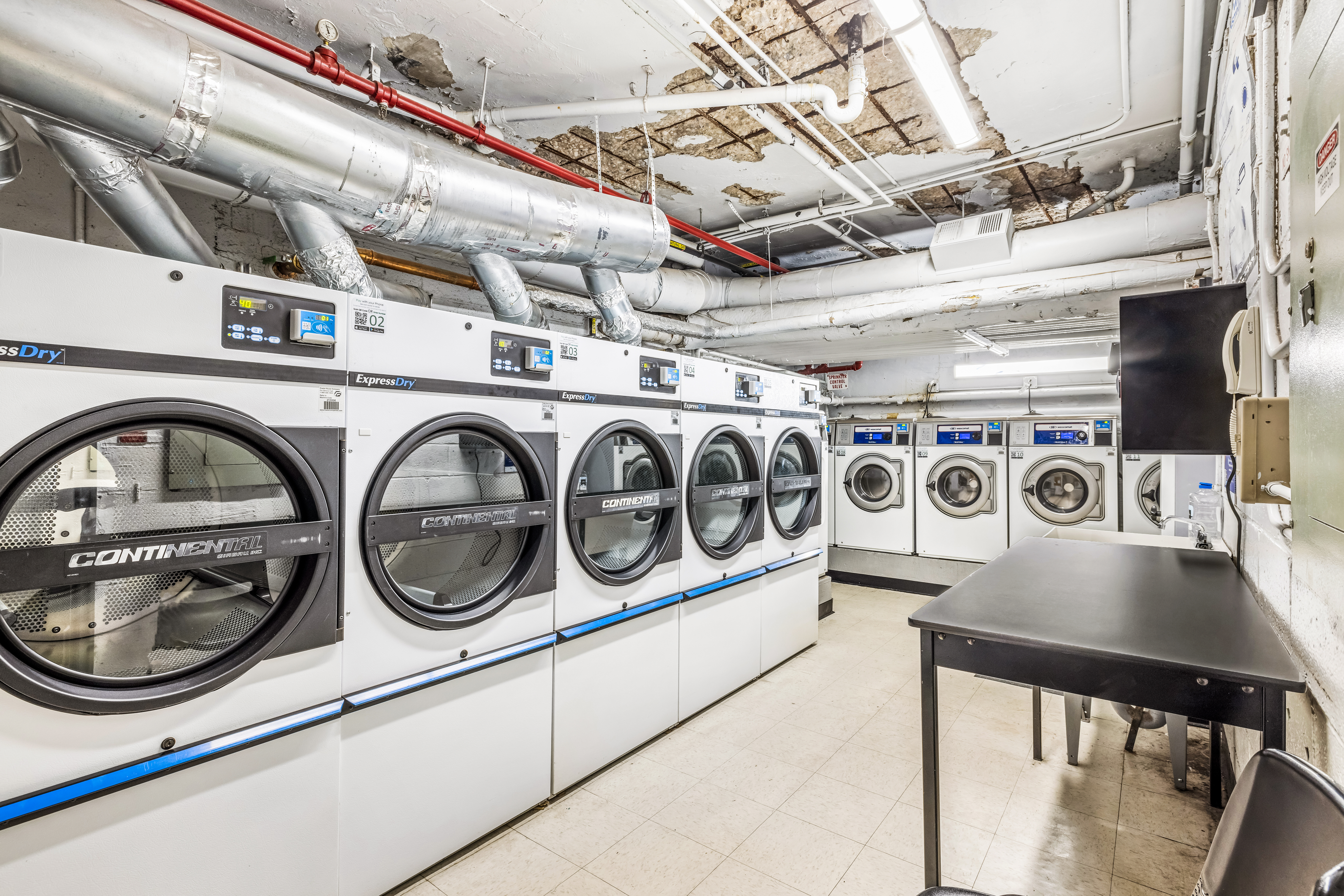 139 East 33rd Street, Unit 3M Manhattan, NY 10016 - Photo 9 of 11 a utility room with multiple dryer and washer