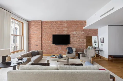 a living room with furniture wooden floor and a flat screen tv