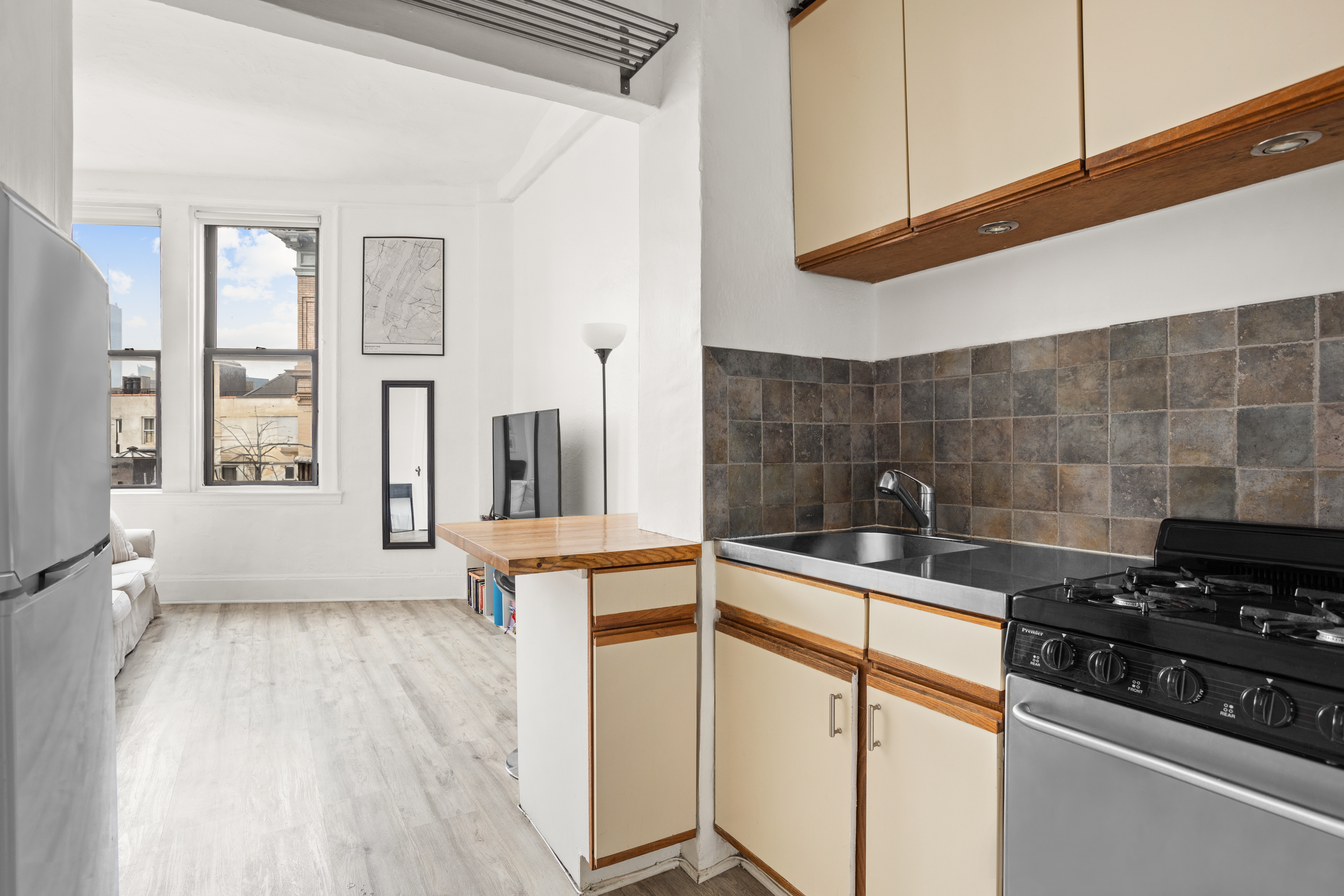 1 Sheridan Square, Unit 6E Manhattan, NY 10014 - Photo 3 of 7 a kitchen with granite countertop a sink a stove and cabinets