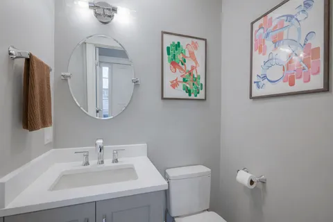 a bathroom with a toilet a sink and mirror
