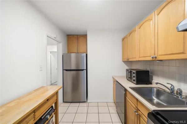 a kitchen with a sink a refrigerator and cabinets