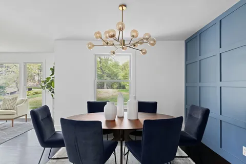 a kitchen with white cabinets and dining table chair
