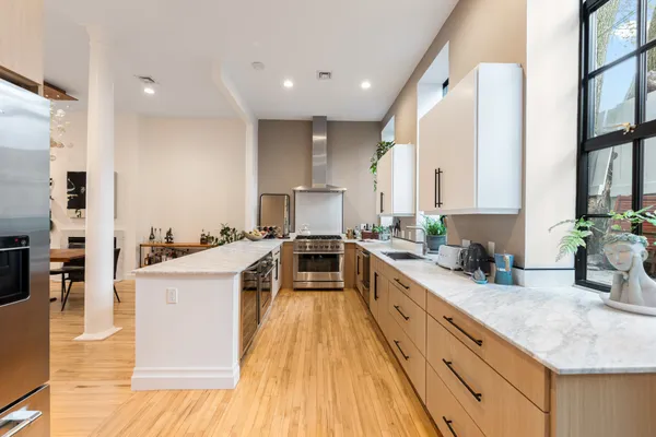 a large kitchen with stainless steel appliances granite countertop a lot of counter space and wooden floor