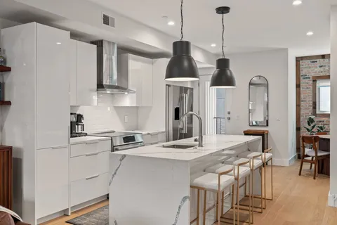 a kitchen with stainless steel appliances kitchen island a dining table chairs and sink