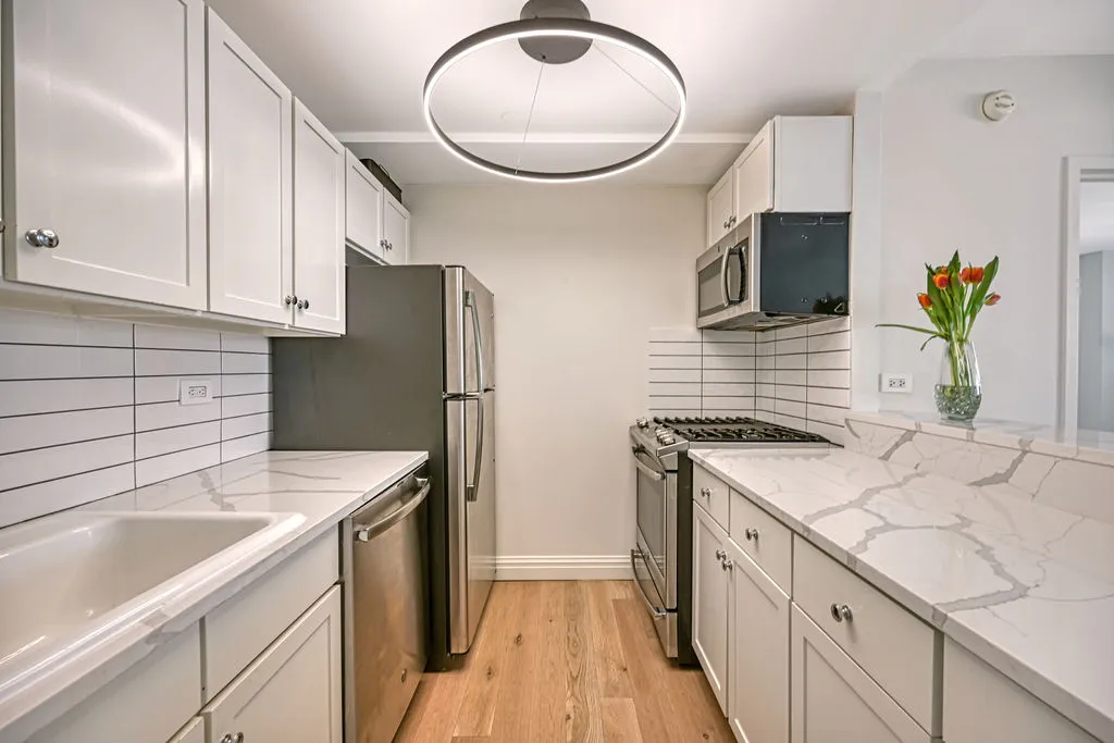 a kitchen with stainless steel appliances granite countertop a sink stove and refrigerator