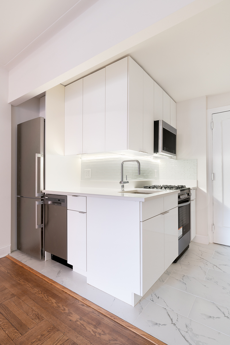 433 West 34th Street, Unit 4K Manhattan, NY 10001 - Photo 6 of 10 a kitchen with granite countertop a sink and a stove top oven