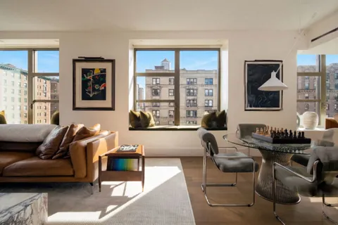 a living room with furniture and floor to ceiling windows