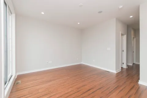 an empty room with wooden floor and entrance