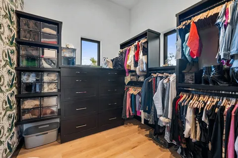 a view of walk in closet with clothes and shoes