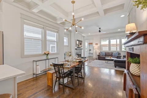 a kitchen with kitchen island granite countertop stainless steel appliances a sink a stove a table and chairs