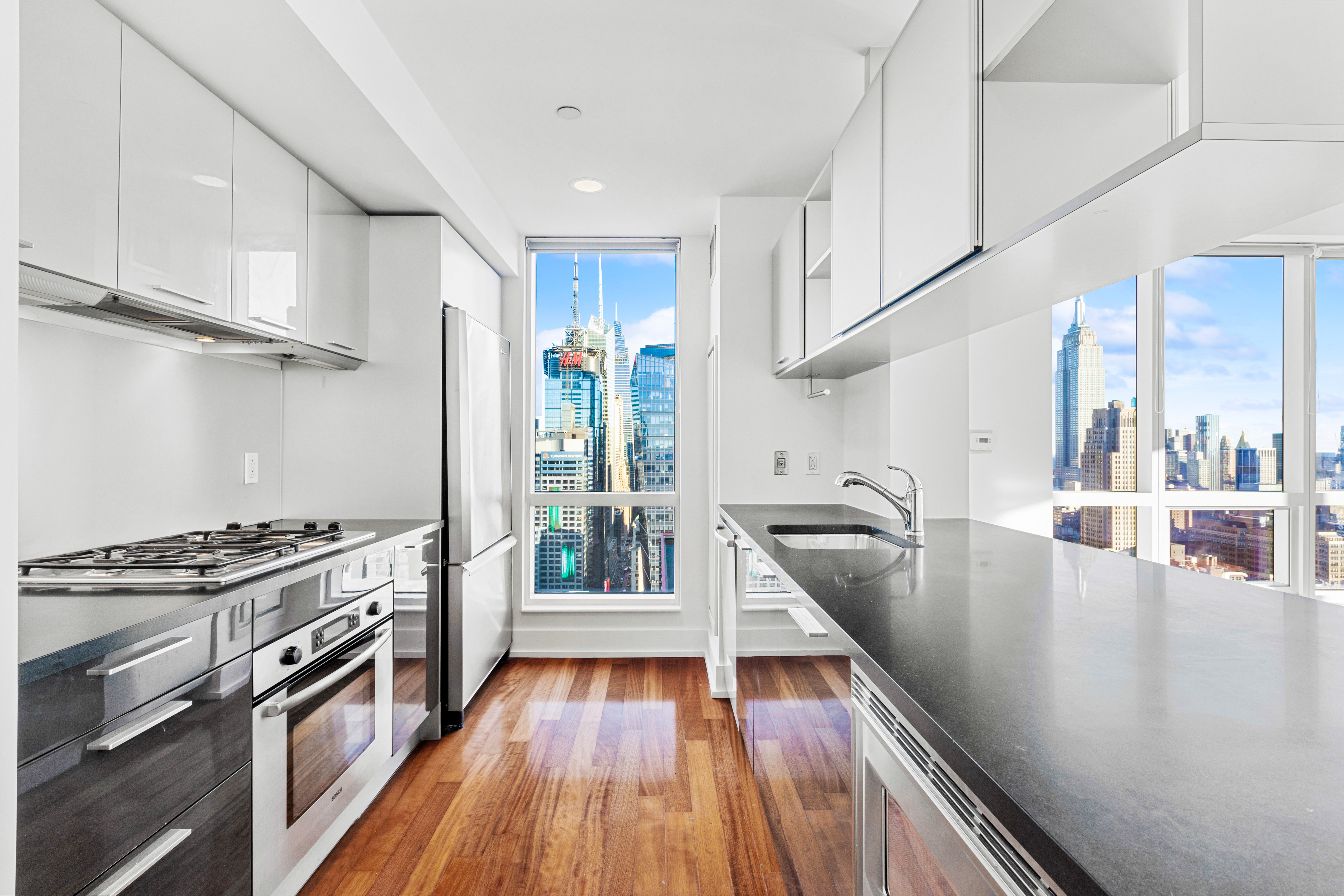 350 West 42nd Street, Unit 48E Manhattan, NY 10036 - Photo 5 of 17 a kitchen with wooden floors and a stove