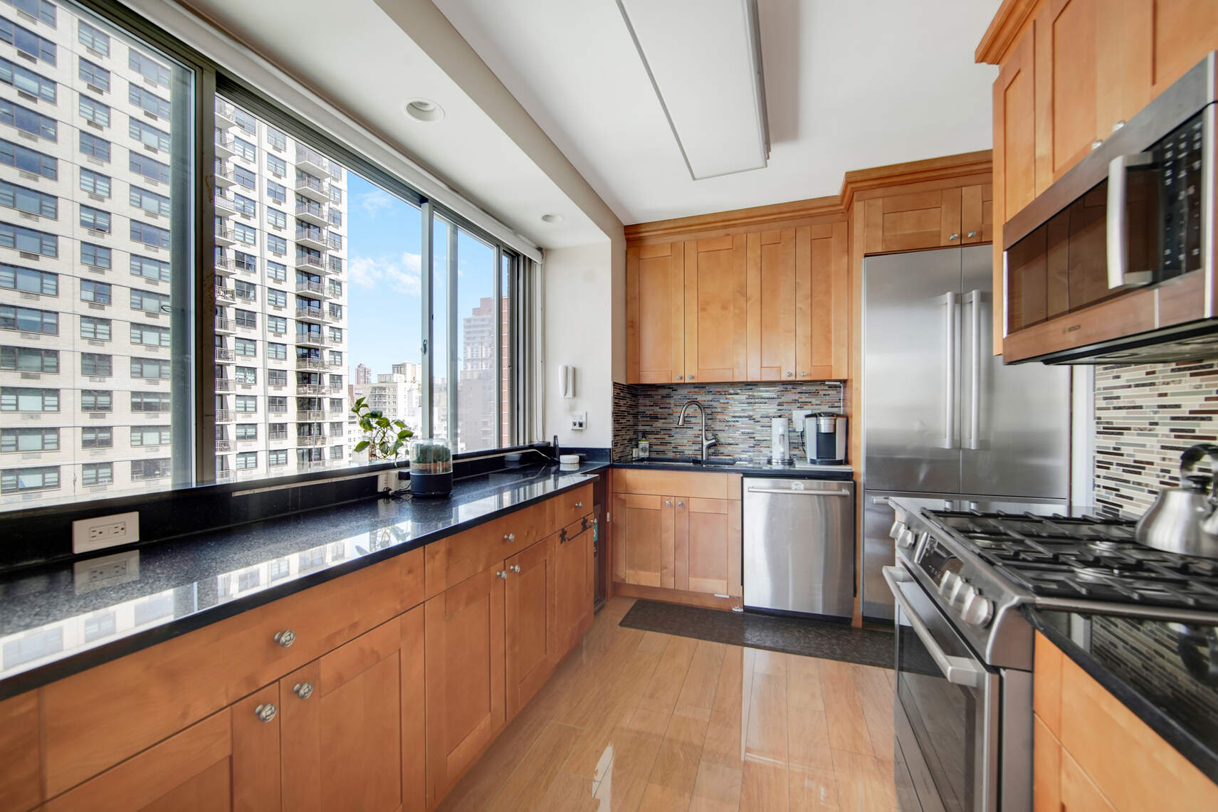 300 East 74th Street, Unit 14F Manhattan, NY 10021 - Photo 5 of 13 a kitchen with stainless steel appliances granite countertop a sink a stove and a refrigerator