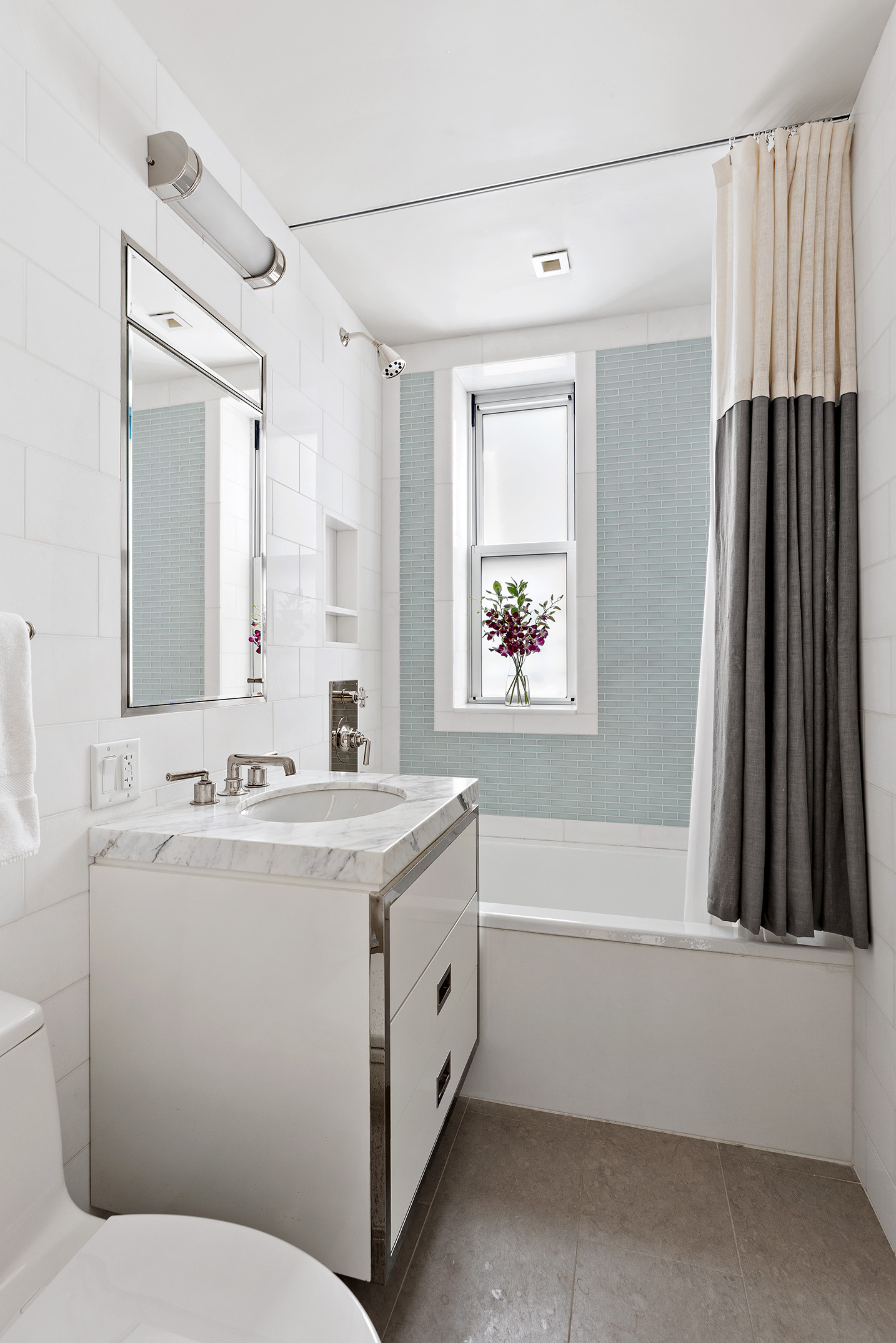 141 East 88th Street, Unit 7A Manhattan, NY 10128 - Photo 7 of 15 a bathroom with a sink a toilet and a mirror